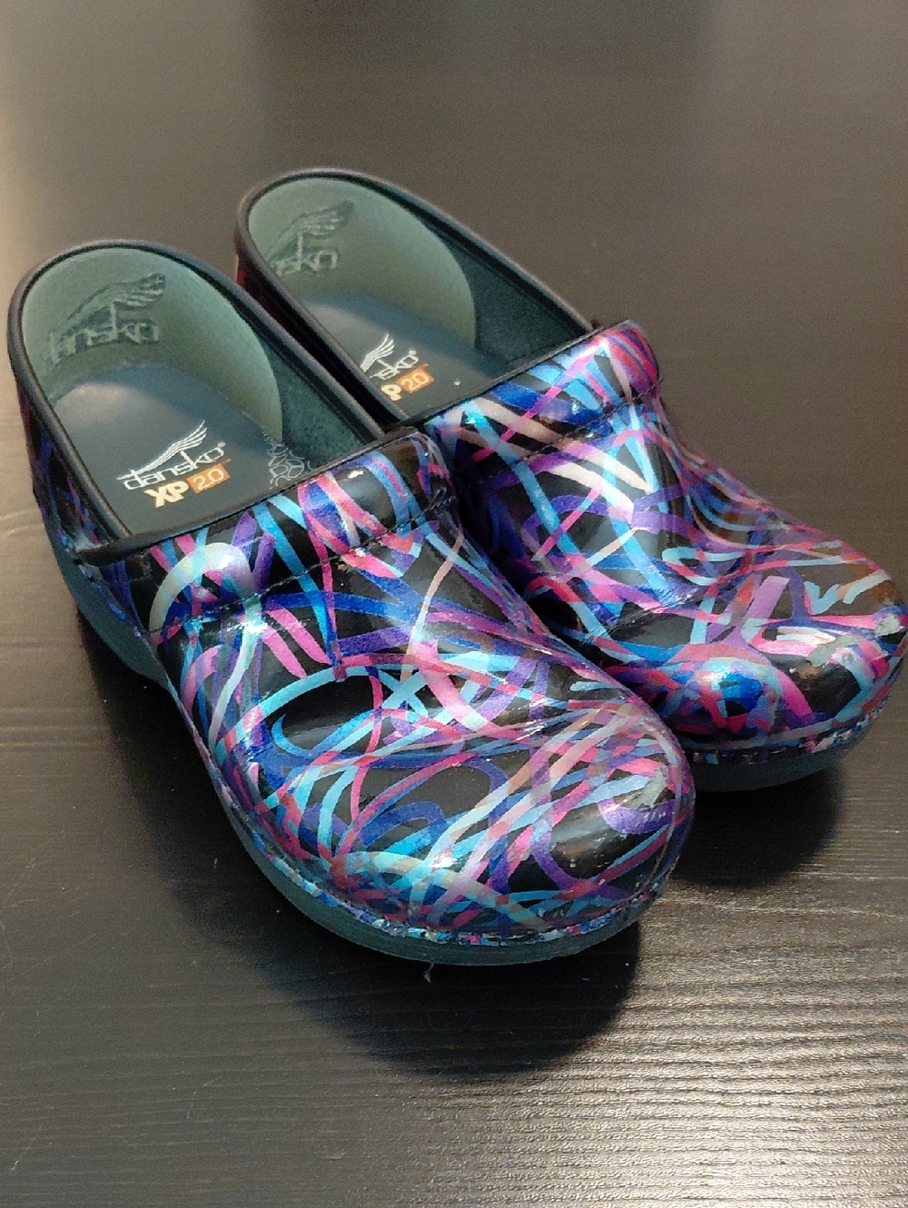Dansko clogs in black with blue, purple and pink swirl accents